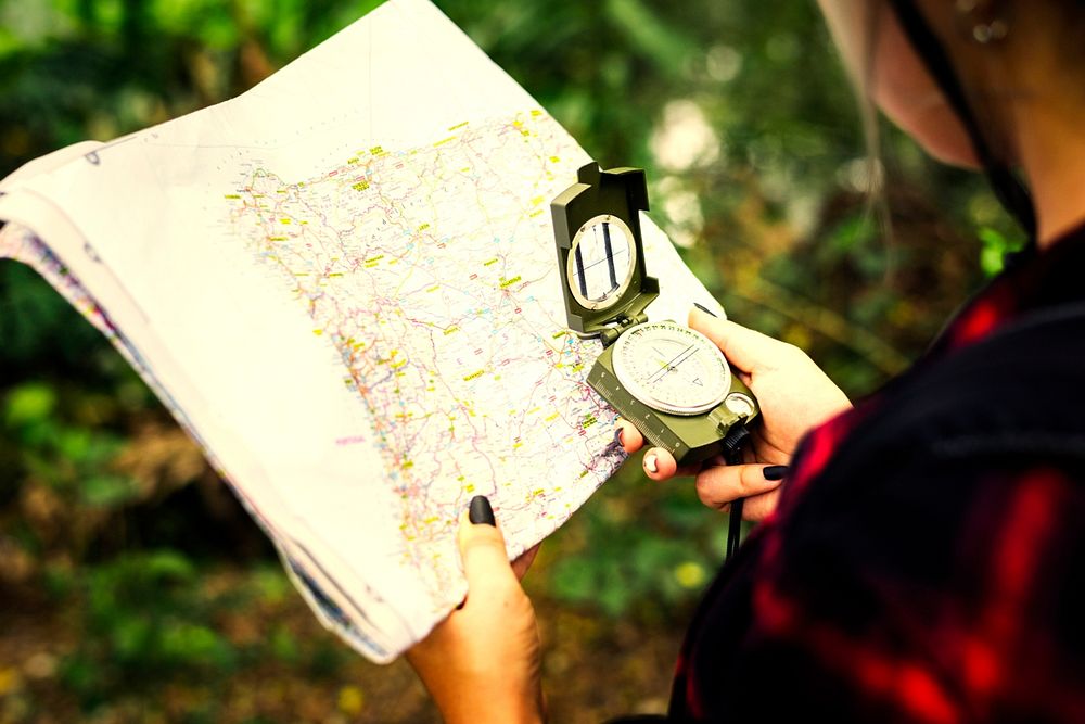 Woman with a map trekking through a forest