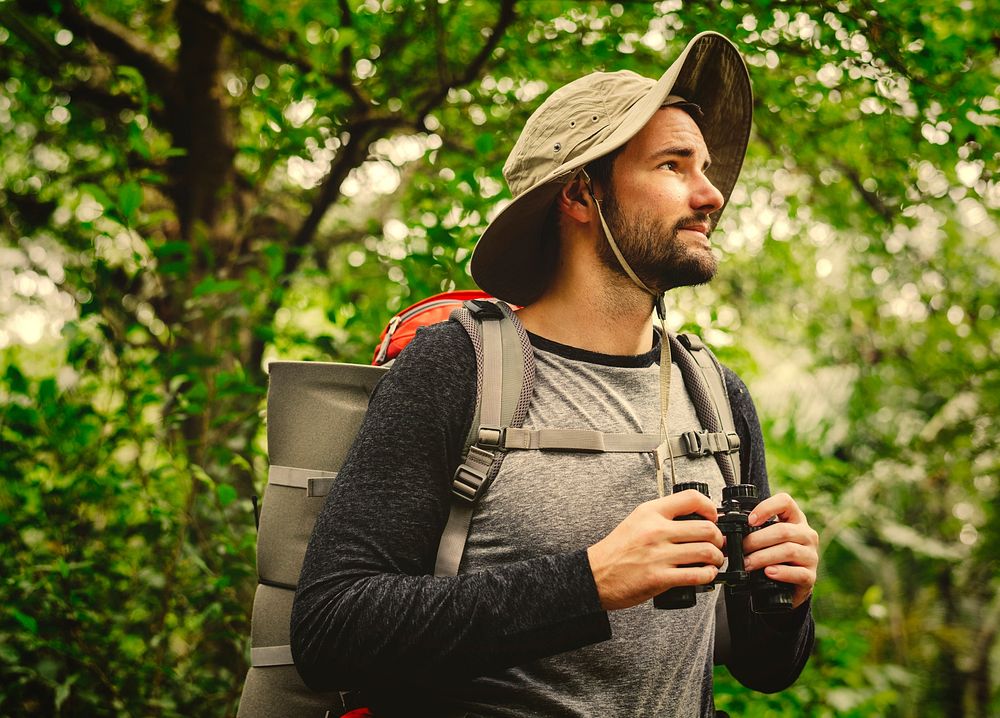 Man with backpack trekking through a forest