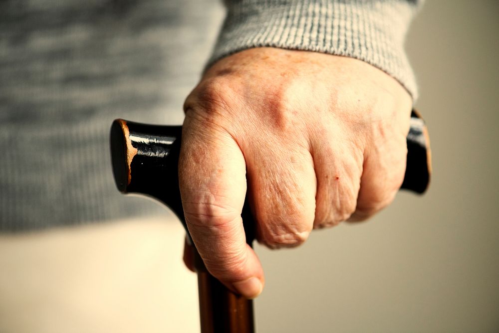 Closeup of elderly woman holding a walking stick