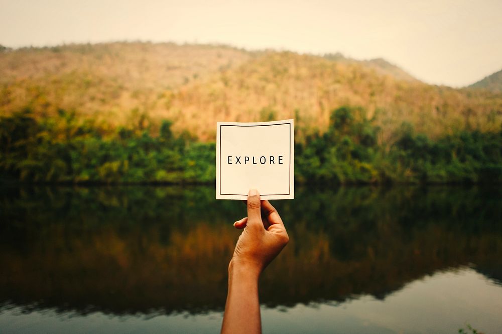 Woman holding up the word explore in nature
