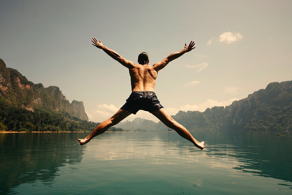 Man jumping with joy by a lake