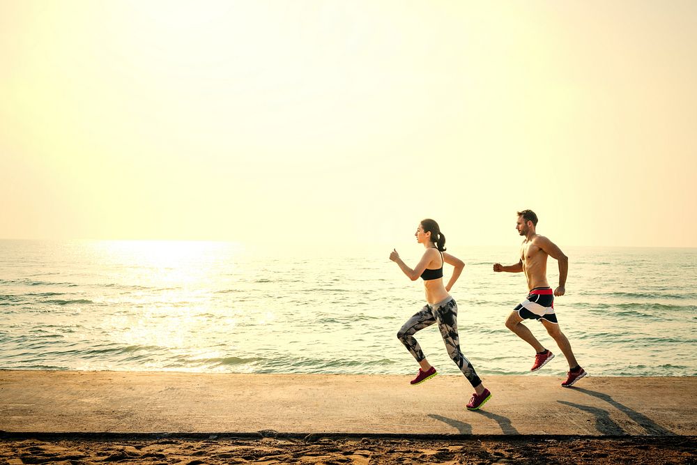 Active couple jogging at the beach