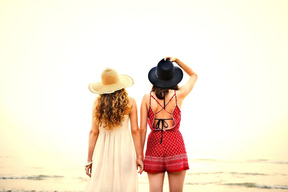 Girlfriends holding hands at the beach