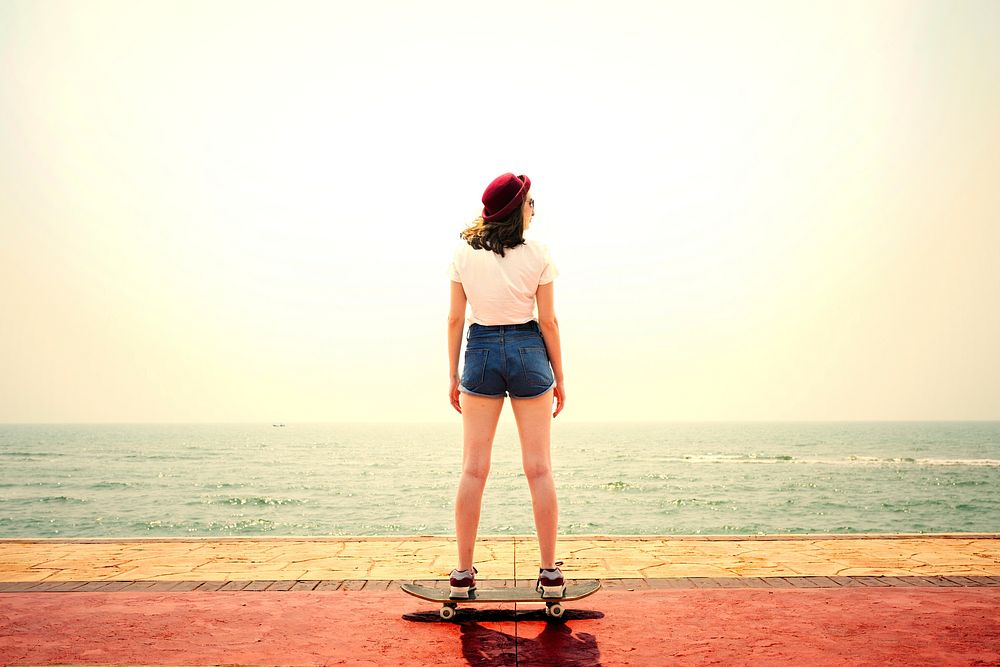 Girl skateboarding by the beach