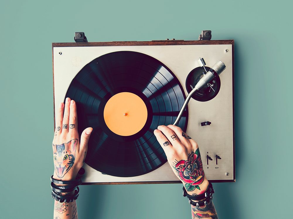 Tattooed woman putting on a vinyl record