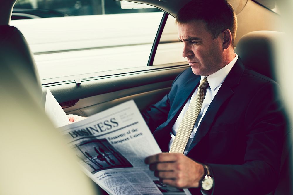 Businessman reading the news in the car