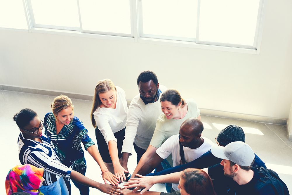 Diverse people joining together as a team