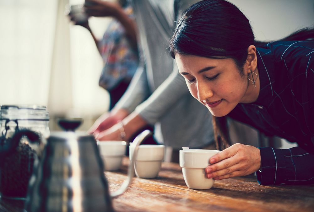 Woman smelling the aroma of a cup of coffee