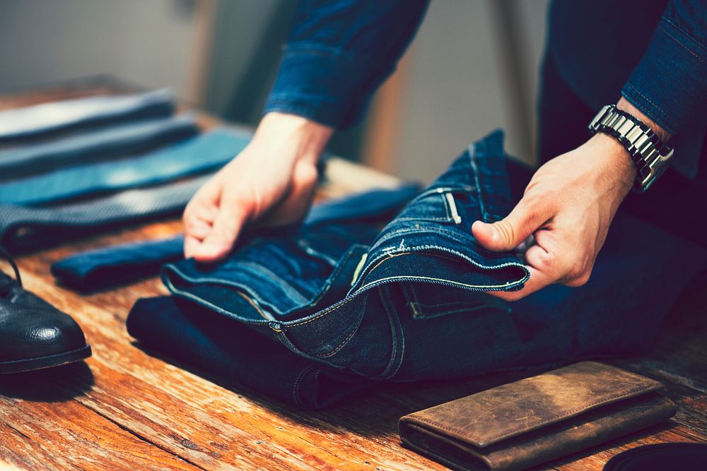 Man unfolding a pair of jeans