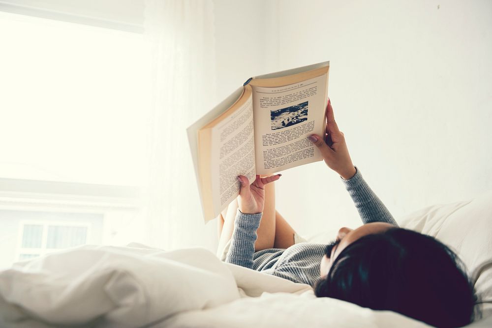 Asian girl reading on bed