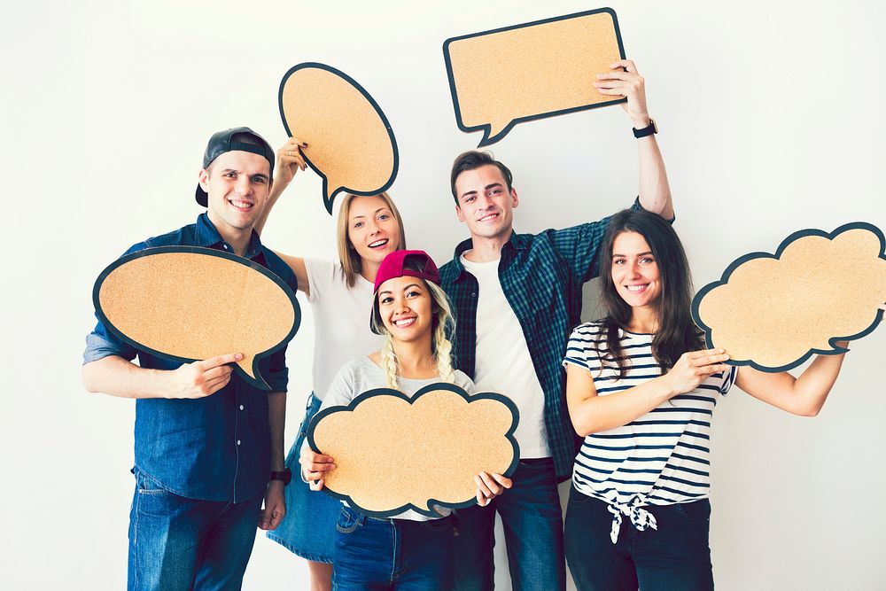 Happy young friends holding up speech bubbles
