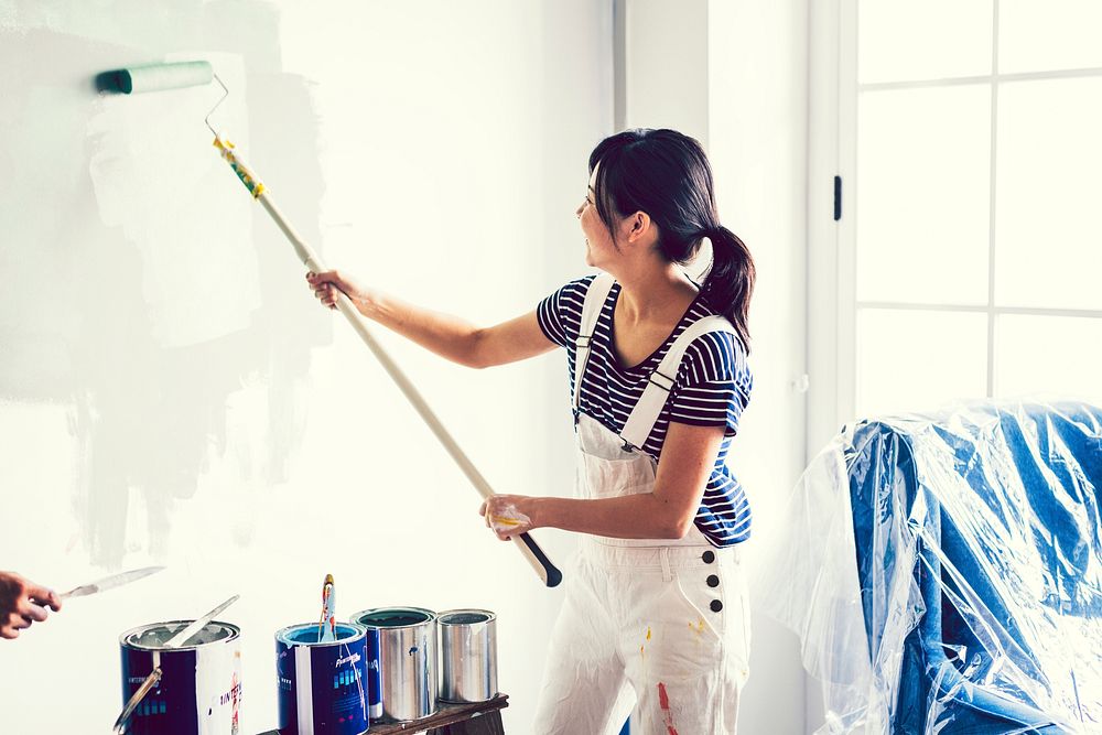 Asian woman painting the wall