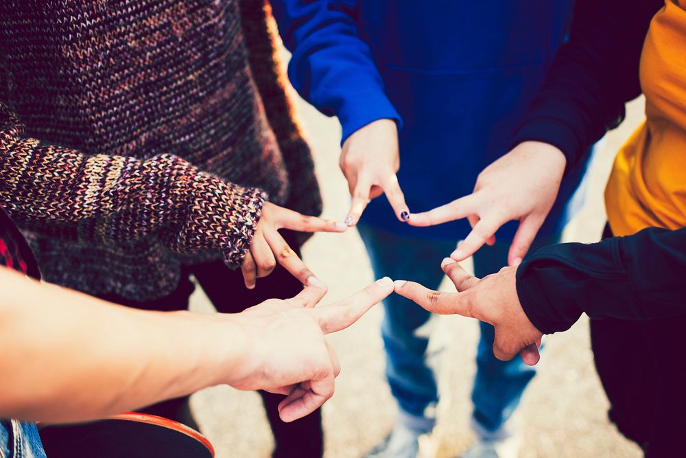 Group of friends using fingers to form a star