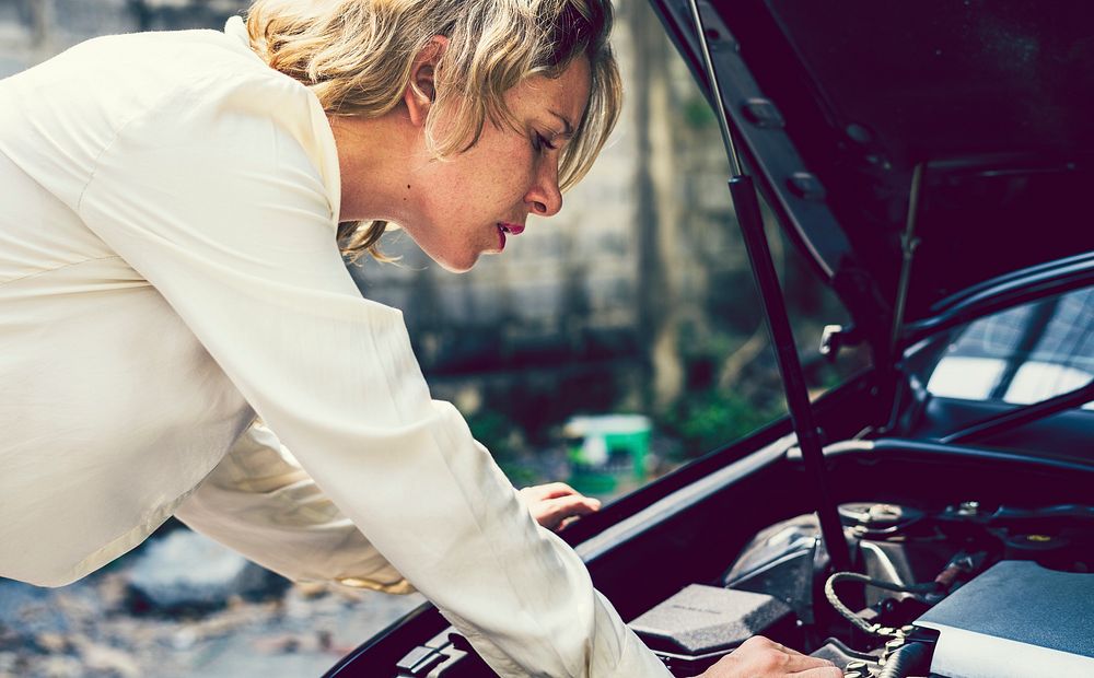 Blonde Woman fixing her car