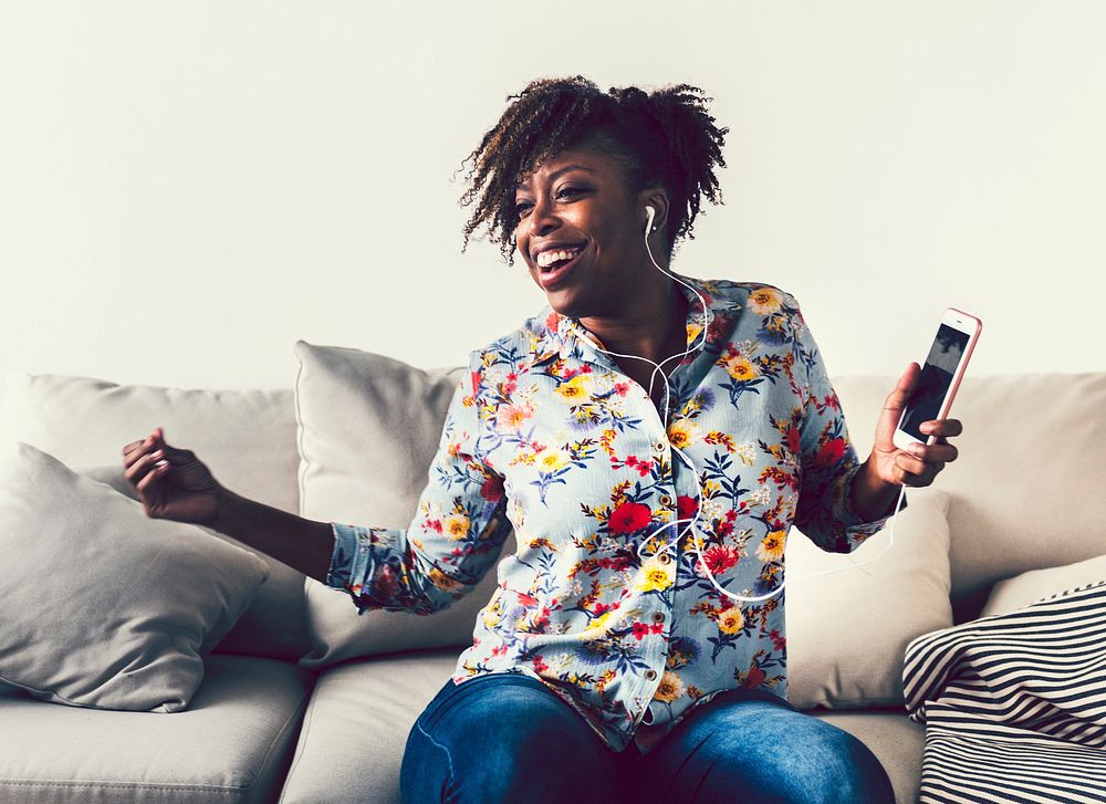 African American woman enjoying music at home