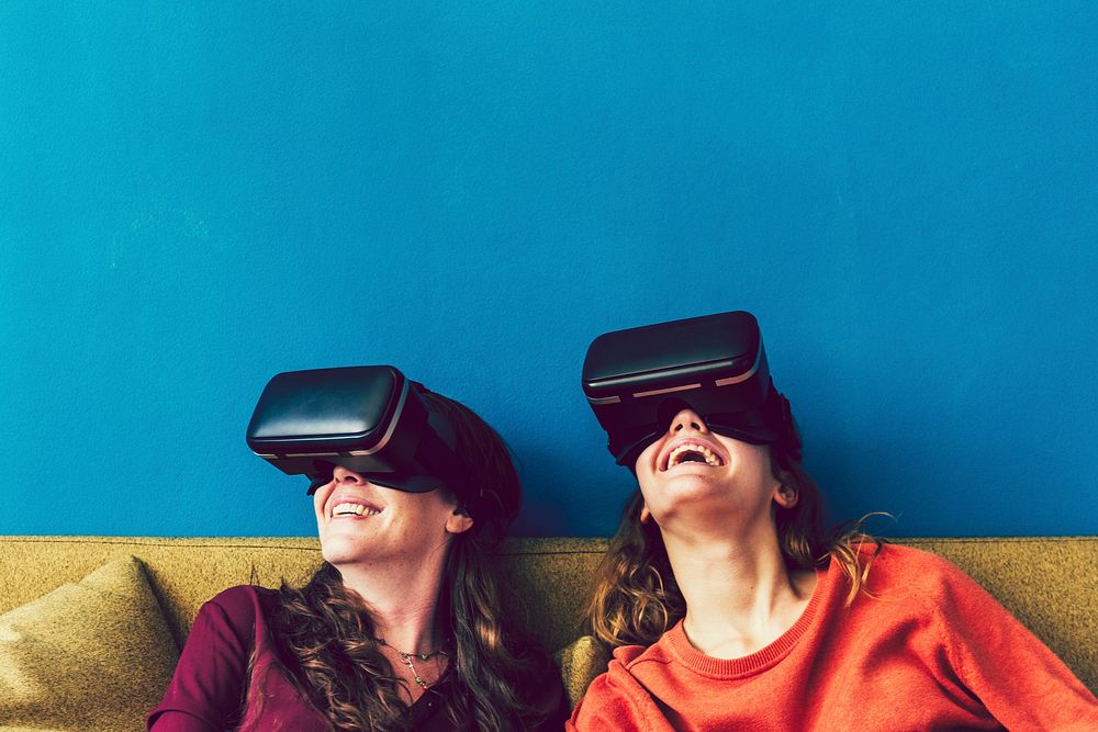 Two women using VR on a sofa