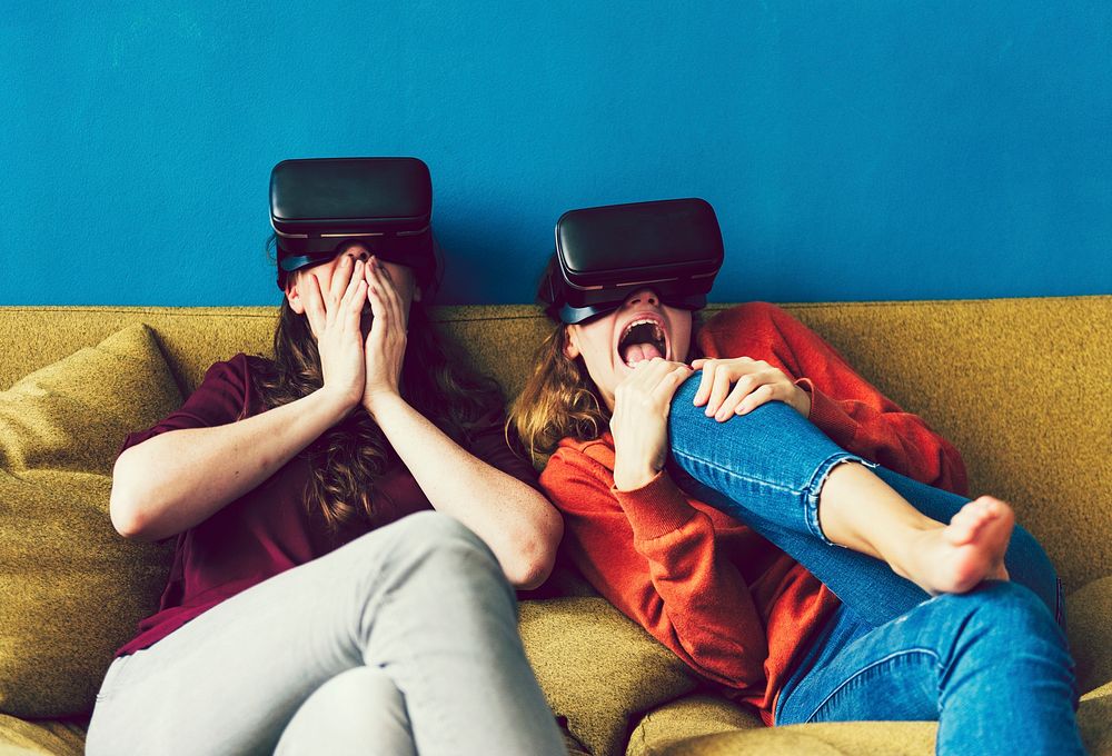 Two women using VR on a sofa