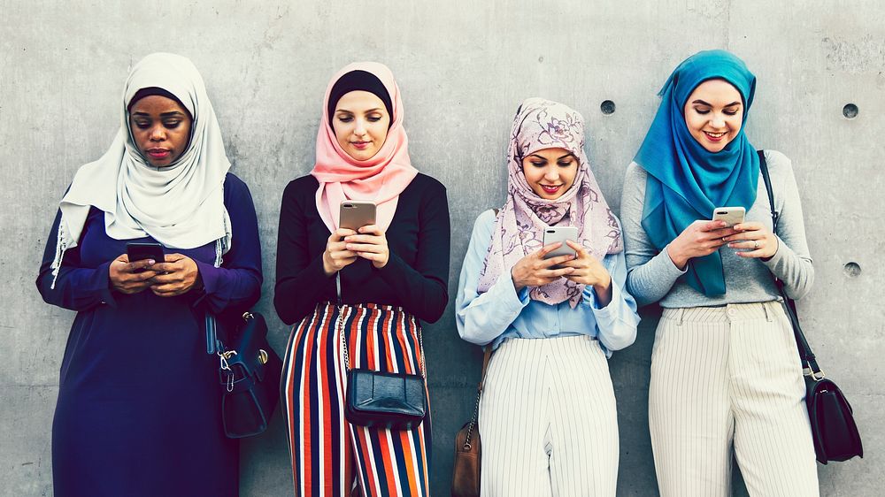Group of Muslim girls using smartphones