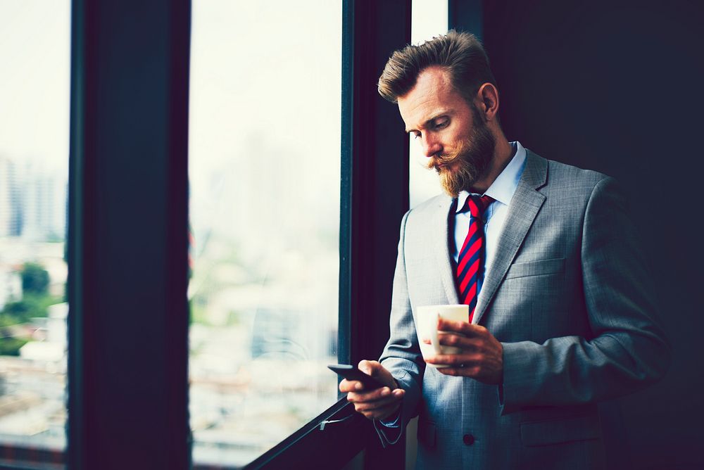 Bearded businessman checking his phone