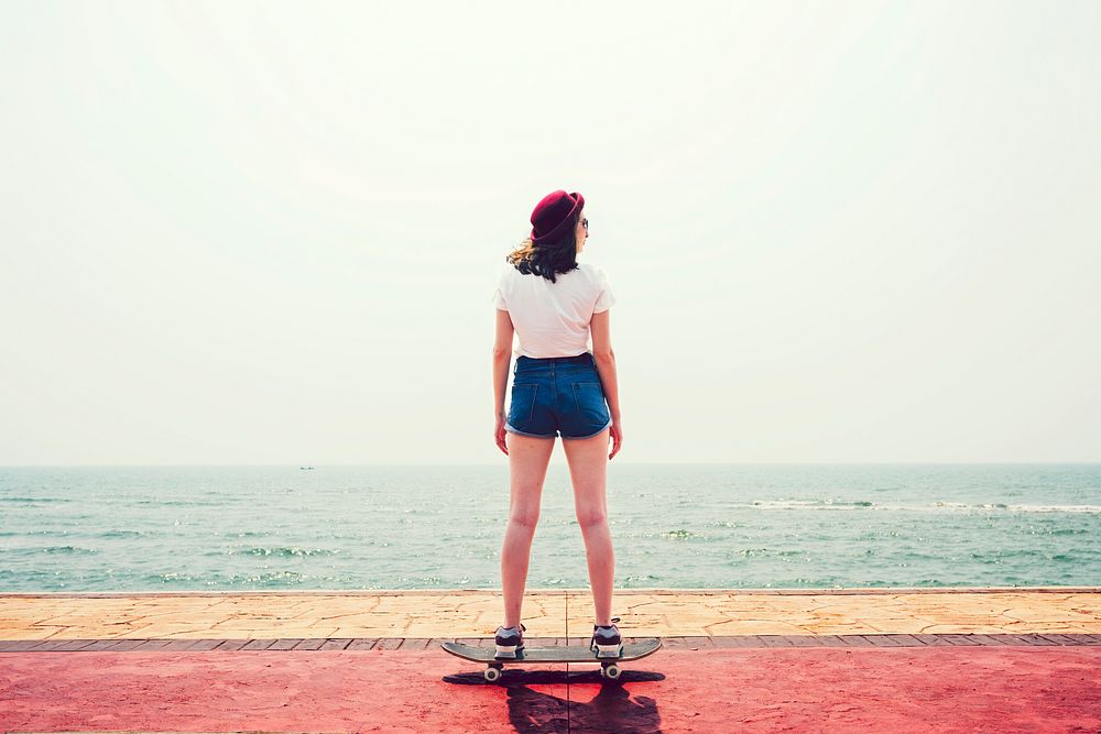 Girl on a skateboard by the beach