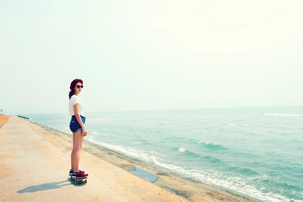 Girl on skateboard by beach