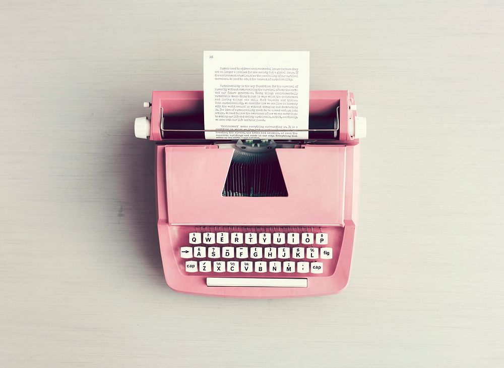 Retro pastel typewriter on grey surface