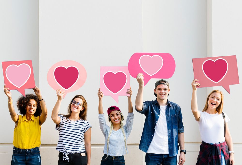 Young adult friends holding up heart icons