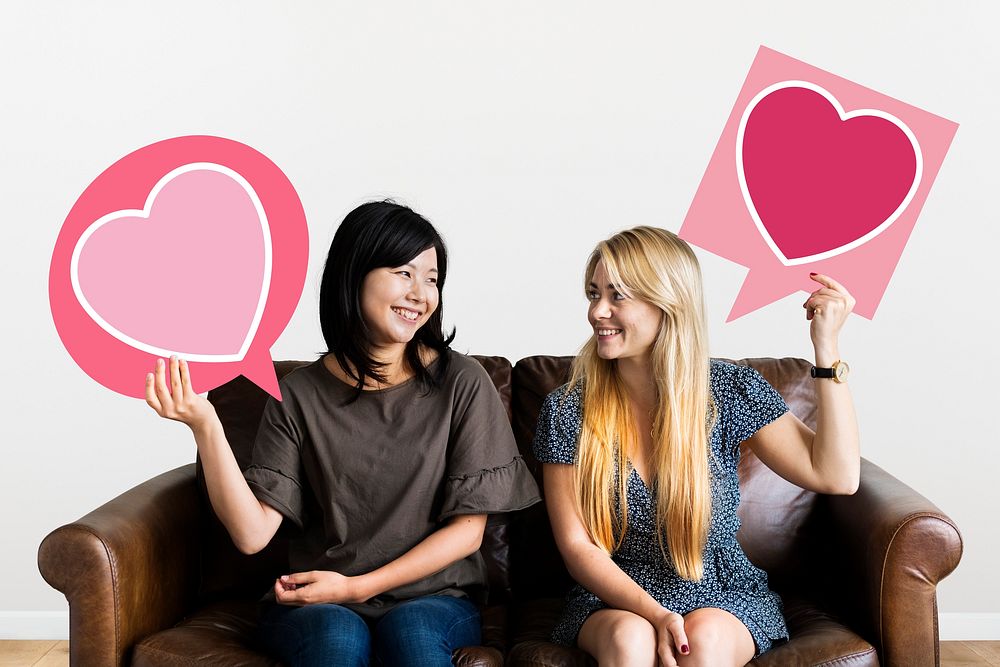 Couple holding speech bubbles with heart icons