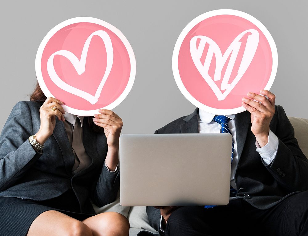 Business couple holding heart icons