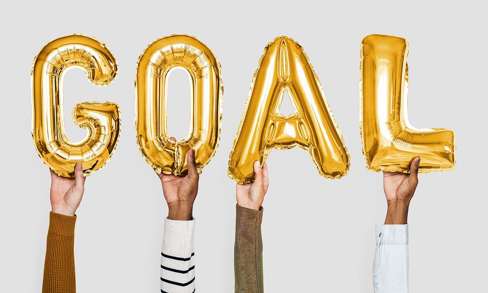 Yellow gold alphabet helium balloons forming the text goal
