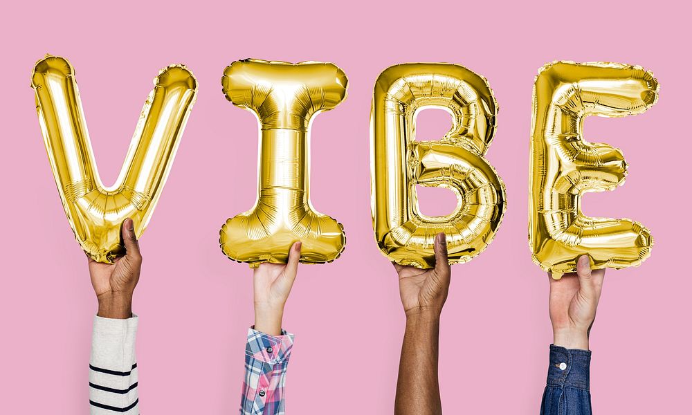 Yellow gold alphabet balloons forming the word vibe