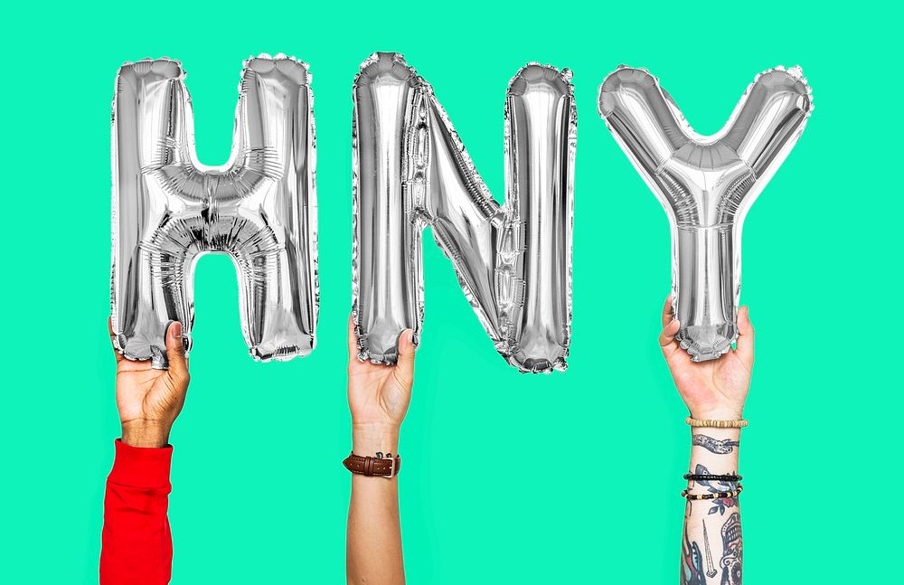 Hands holding balloons spelling HNY