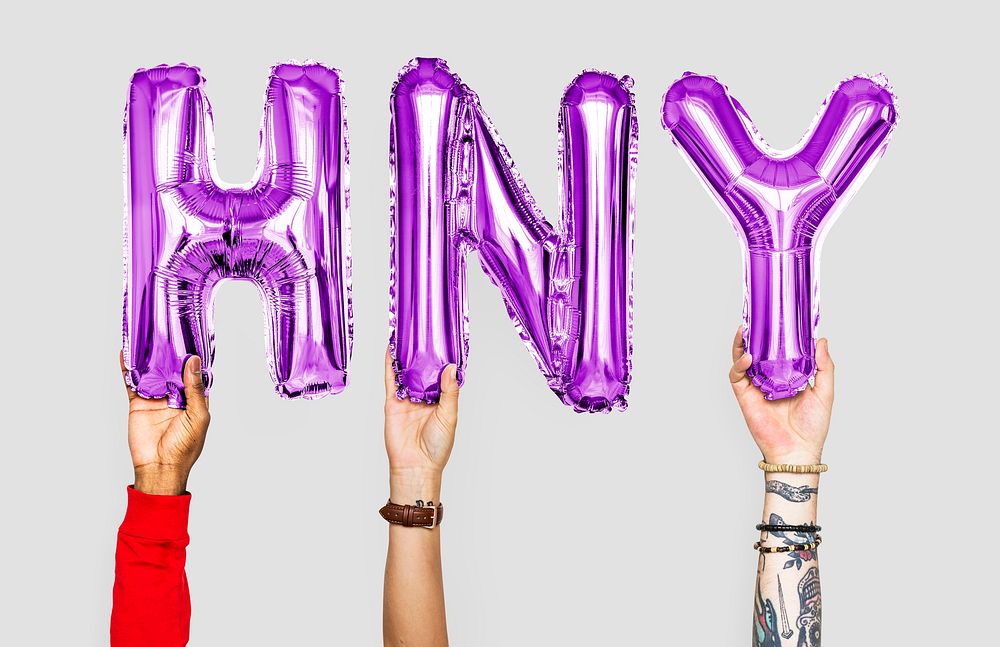 Hands holding balloons spelling HNY