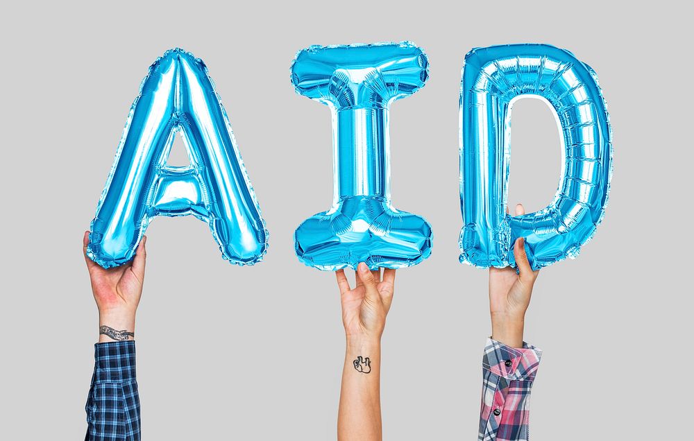 Hands holding aid word in balloon letters