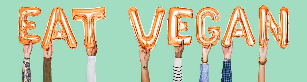 Hands holding Eat Vegan word in balloon letters