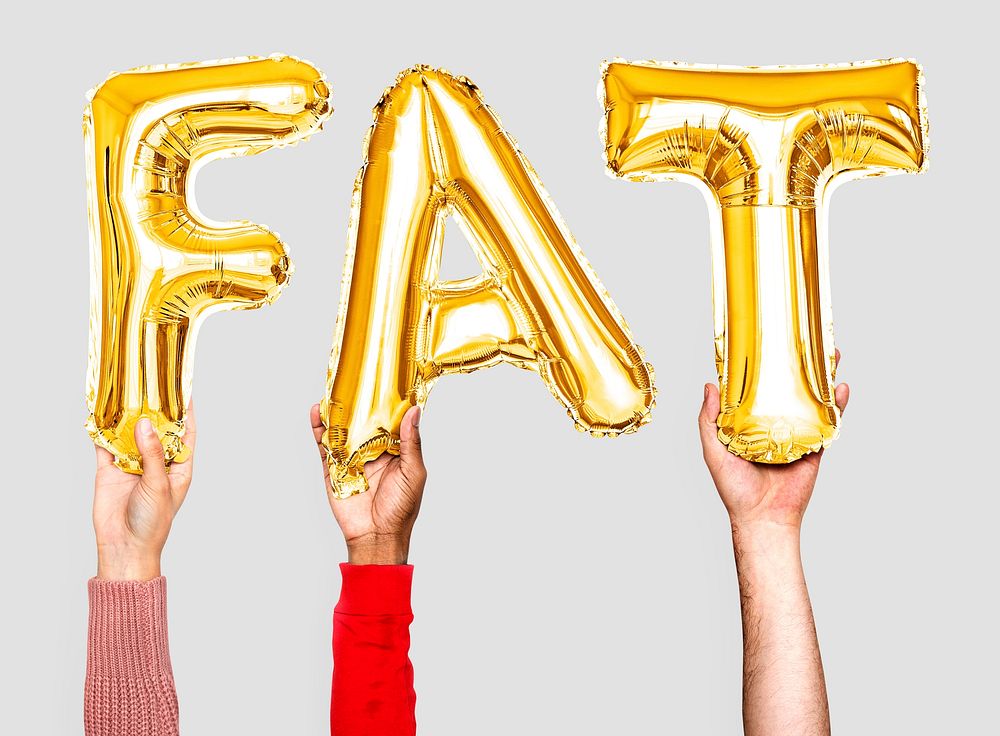 Hands holding balloons spelling Fat