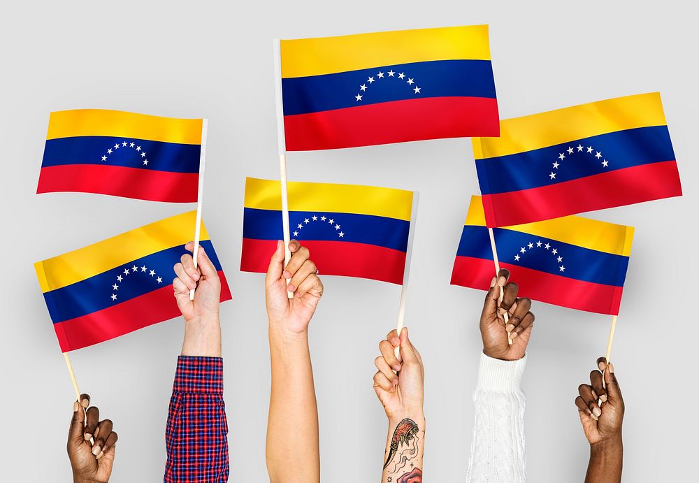 Hands waving flags of Venezuela