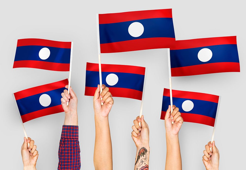 Hands waving flags of Lao PDR