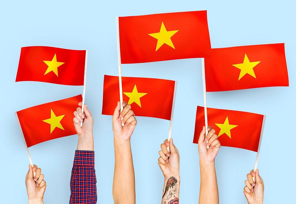 Hands waving flags of Vietnam