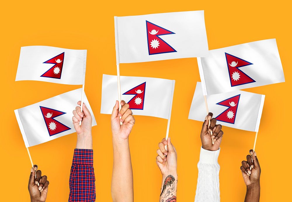Hands waving flags of Nepal