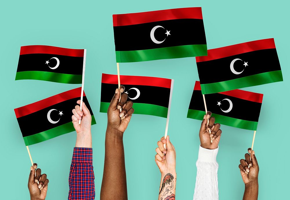 Hands waving flags of Libya