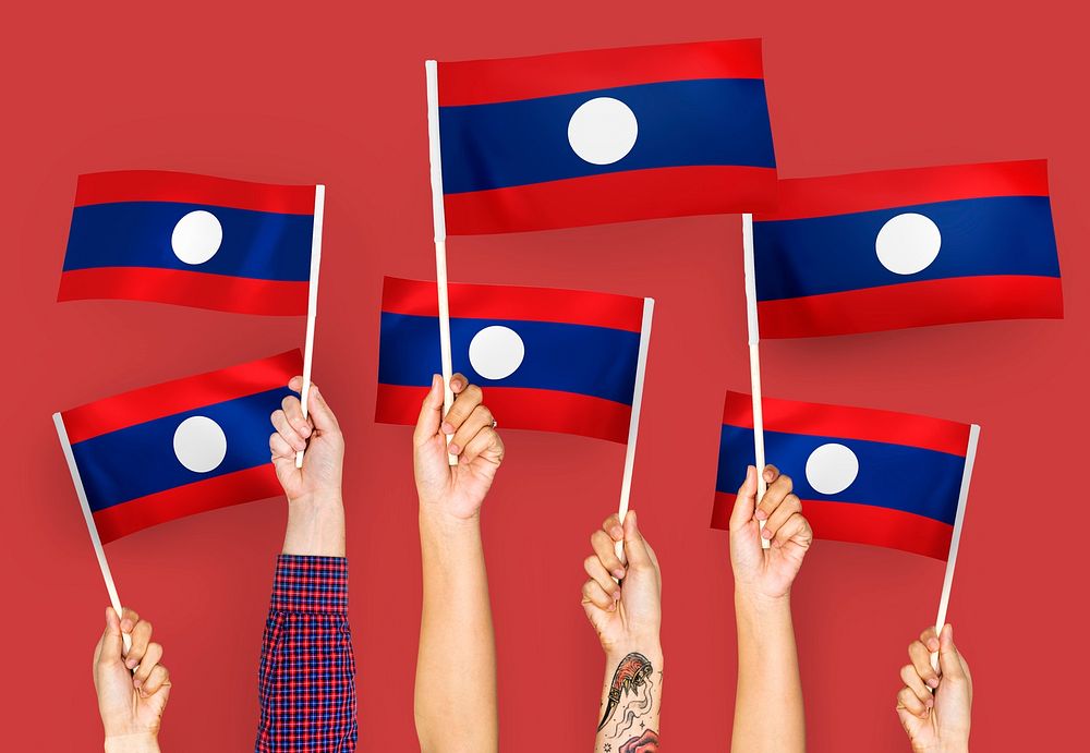 Hands waving flags of Lao PDR