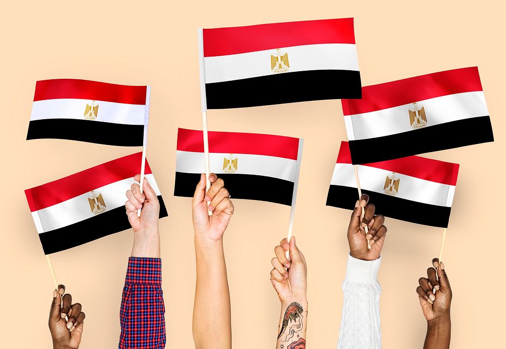 Hands raising Egypt national flags