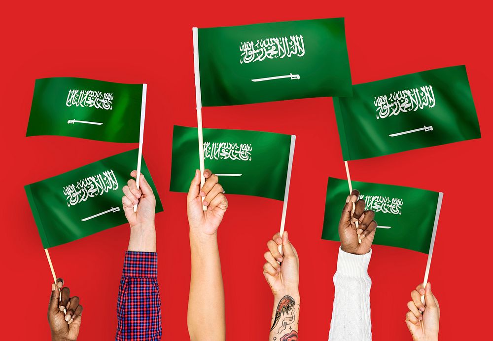 Hands waving the flags of Saudi Arabia
