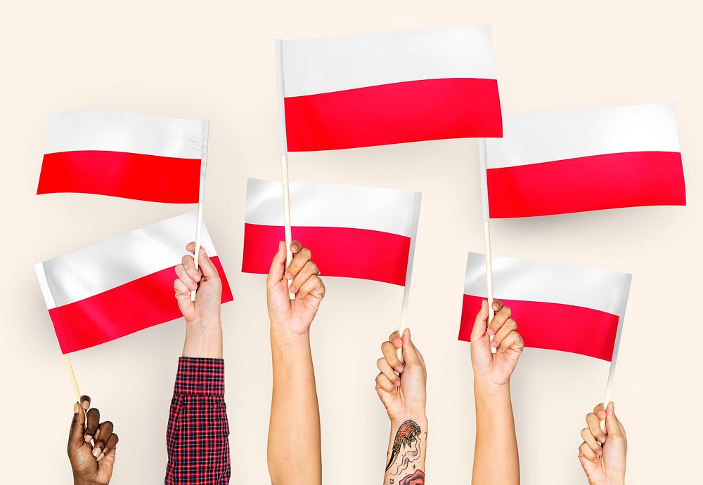 Hands waving the flags of Poland