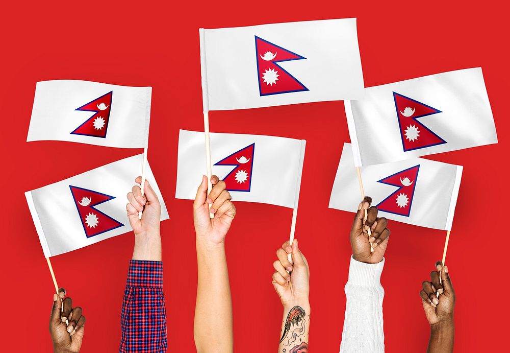 Hands waving flags of Nepal