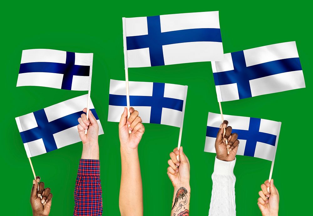 Hands waving flags of Finland