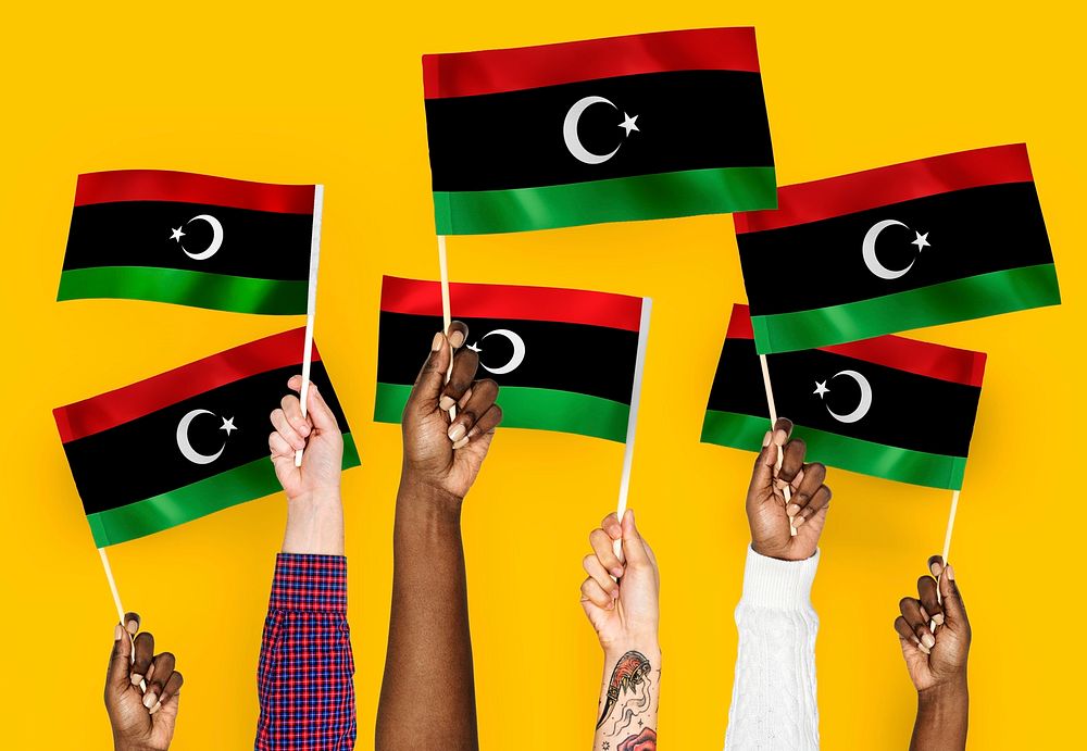 Hands waving flags of Libya