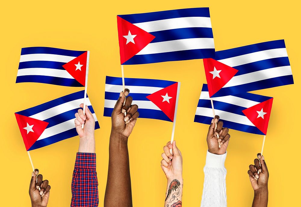 Hands waving flags of Cuba