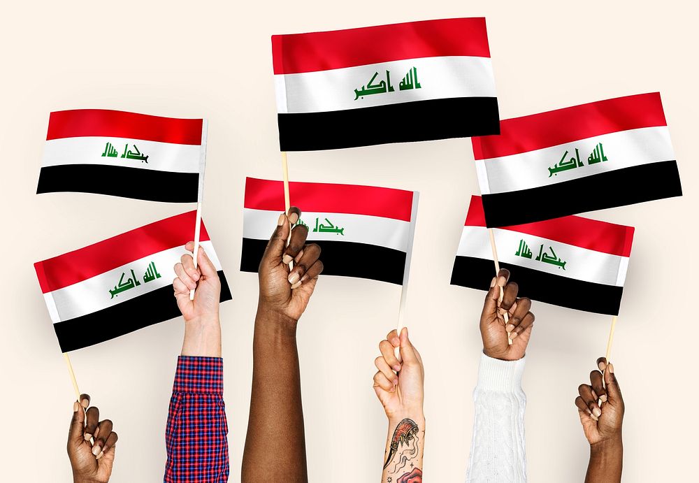 Hands waving flags of Iraq